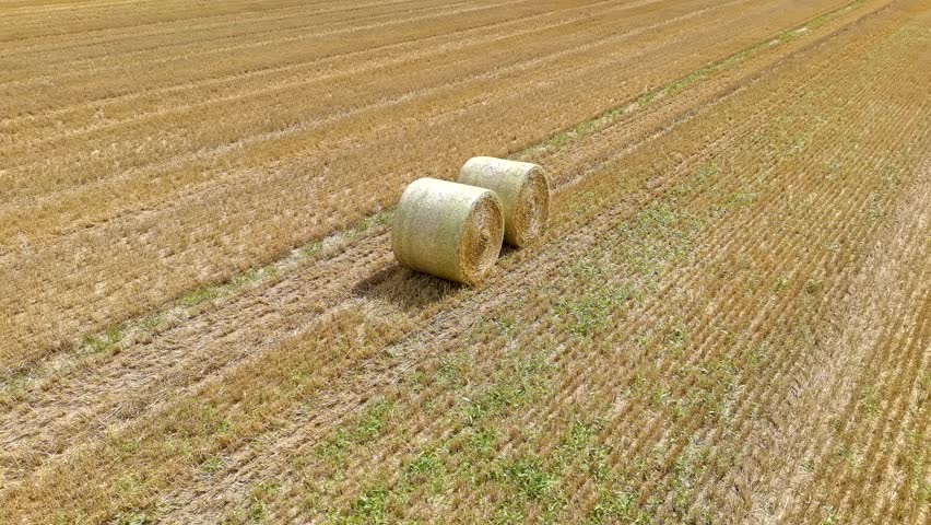Aerial Drone Footage of Two Hay Bales in Harvested Field