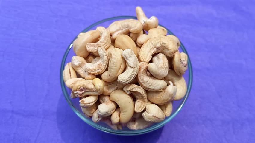 A bowl filled with cashew nuts. These nuts are commonly enjoyed as a snack and are also used in various dishes. 