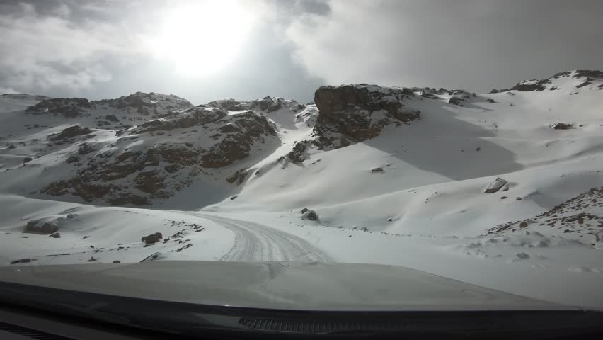 Driving car on the snowing mountain trail in tibet, China