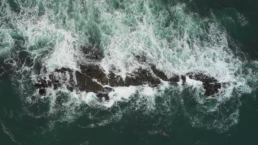Aerial top down view of waves splashing into rocks in the sea, super slow motion - Travel and nature concepts, background ready HD video