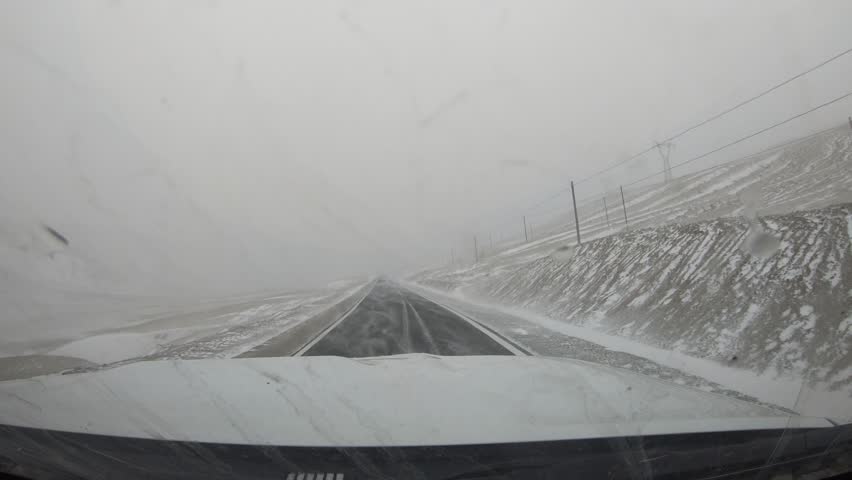 Driving car on the snowing mountain trail in tibet, China