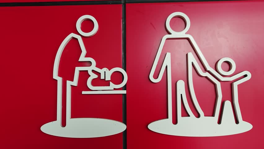Public restroom symbol for children on a red wall.