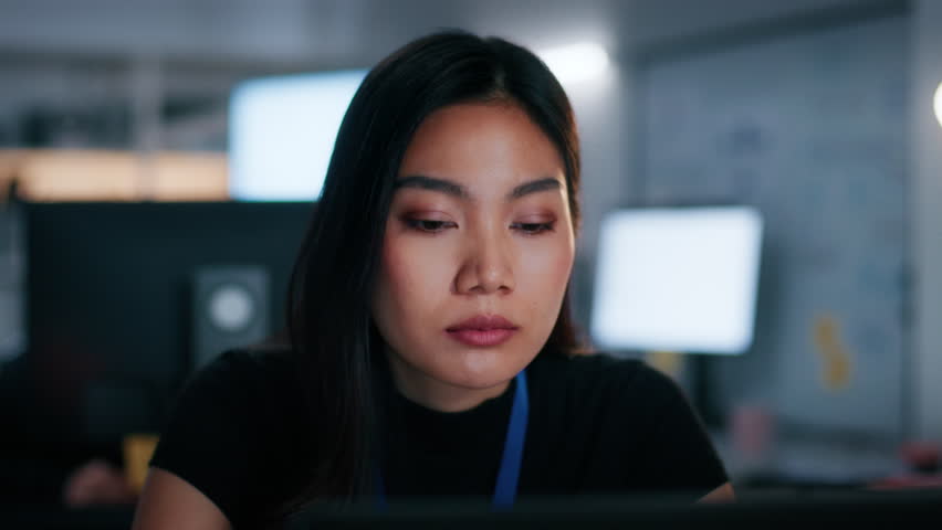 Sleepy and Tired Asian Businesswoman Sitting at Desk with Laptop computer, Working Overtime. Exhausted Female Office worker struggling to stay awake, Feeling Fatigue, Stress While Working Overtime.