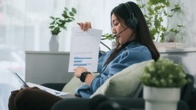 Professional Asian Business Woman Worker Sitting at Home Office, Reviewing Business Charts, Presenting Report Documents, and Explaining Analysis During Remote Work Online Meeting sit on sofa at home. - Powered by Shutterstock - Get 15% off with code: PIKWIZARD15