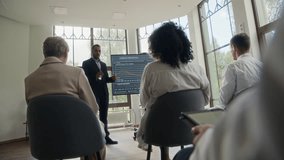 Young Middle Eastern man doing presentation about diabetes in front of diverse colleagues during conference in hospital - Powered by Shutterstock - Get 15% off with code: PIKWIZARD15