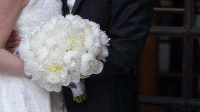 Elegant Wedding Moment with Bride and Groom Holding Bouquet, A refined MP4-fil  wedding video showing a close-up of the groom and bride gently embracing. The white bouquet, - Powered by Shutterstock - Get 15% off with code: PIKWIZARD15