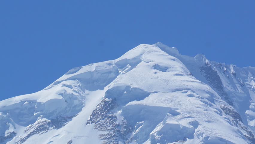K2, also known as Mount Godwin-Austen, the world’s second-highest mountain, located in the Karakoram Range on the border of Pakistan and China.K2 120fps Slow Motion 4K Footage of rocky mountain peak.