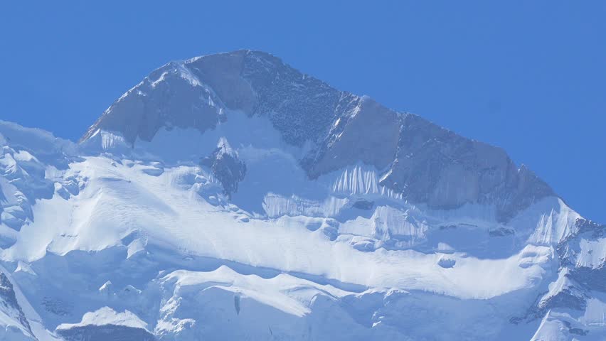 K2, also known as Mount Godwin-Austen, the world’s second-highest mountain, located in the Karakoram Range on the border of Pakistan and China.K2 120fps Slow Motion 4K Footage of rocky mountain peak.