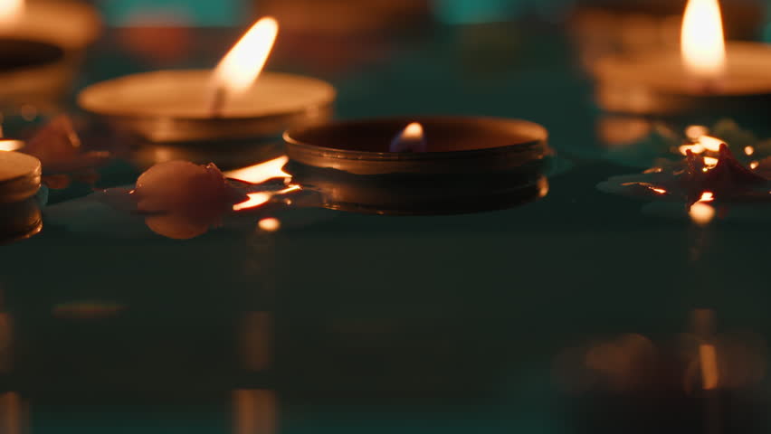 Candles float on the river at night for the Diwali festival celebration
