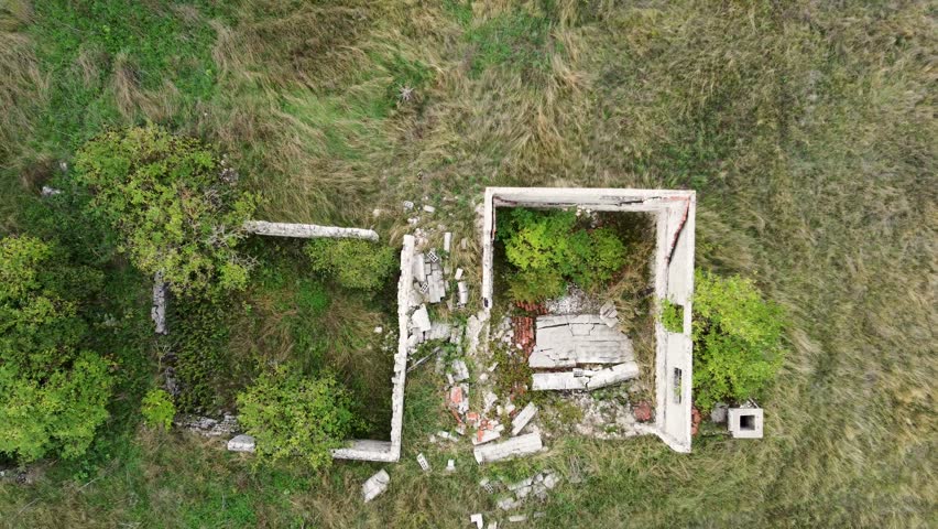 Destroyed village in war, aerial drone view. Ruined and damaged house in village as war aftermath. Houses destroyed and burned by artillery during the war. Houses in ruins. 