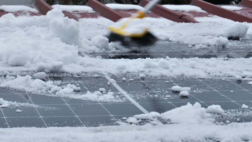 Cleaning solar panels during the winter season.Snow removal from solar panels in winter. brush clears snow from solar panel close-up. 4k footage
