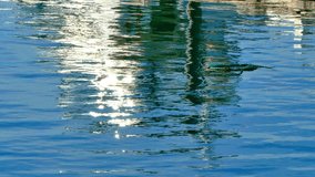Rippling water reflections at the harbor create a mesmerizing pattern of light and color on a sunny day. Ideal background for text and graphics - Powered by Shutterstock - Get 15% off with code: PIKWIZARD15
