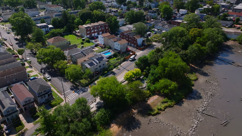 Drone aerial view of the Kill Van Kull waterway with Staten Island and Bayonne shorelines, industrial ports, and distant Manhattan skyline. Maritime shipping route on a clear sunny summer day. ProRes.