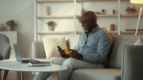 Senior African American man enjoying leisure time at home while using smartphone - Powered by Shutterstock - Get 15% off with code: PIKWIZARD15
