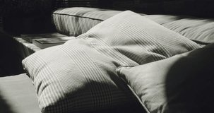 An intimate corner capturing the sunlit coziness on a textured couch with plump cushions, casting intricate shadows. Sunlight Streaming Over Cushions on an Inviting Couch - Powered by Shutterstock - Get 15% off with code: PIKWIZARD15