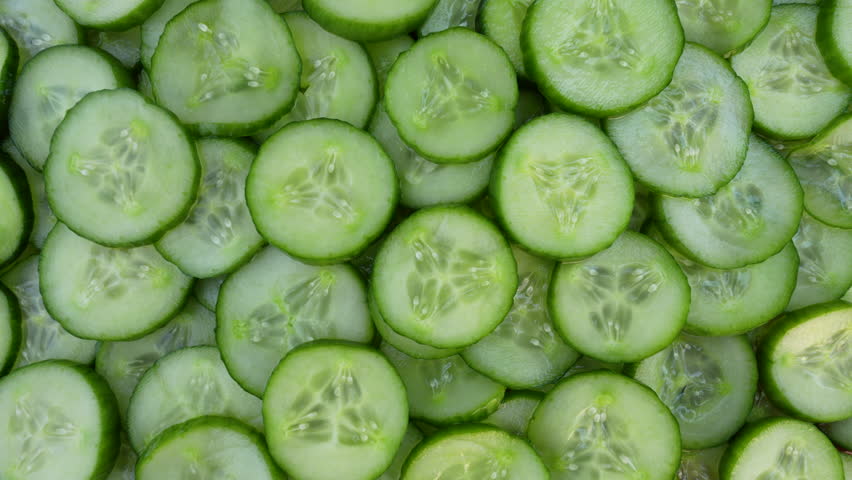Fresh cucumber slices rotating top view. Healthy food. 