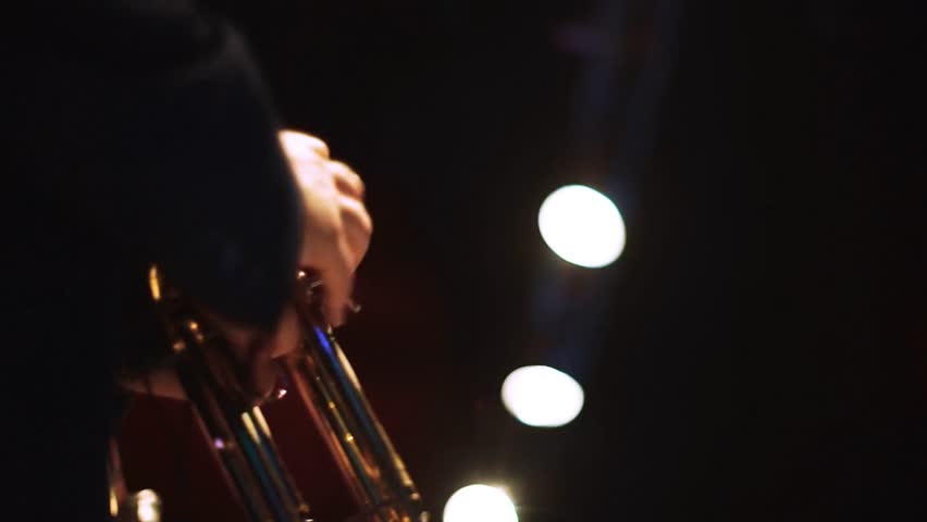 Two men performing on trumpets on stage, capturing live music, jazz performance, stage entertainment, and artistic musical collaboration.