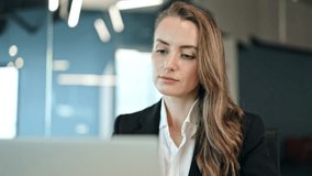 Thoughtful businesswoman works intently on laptop in a modern office. Serious, focused female freelancer in business attire concentrates on her tasks, reflecting thoughtfully on the screen. - Powered by Shutterstock - Get 15% off with code: PIKWIZARD15
