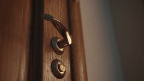 Low-angle view of hand of unrecognizable man gripping golden door handle, signaling imminent movement within softly illuminated hotel room corridor, conveying subtle moment of quiet transition. - Powered by Shutterstock - Get 15% off with code: PIKWIZARD15