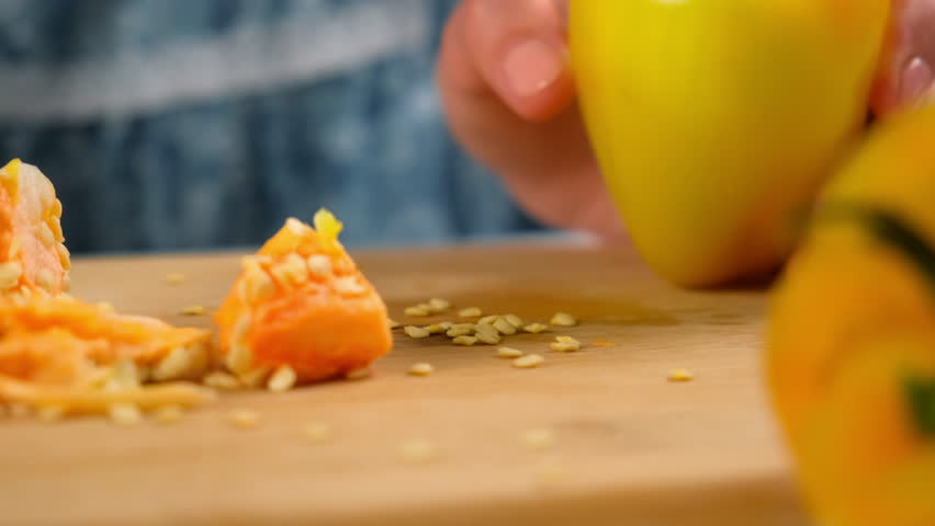 Woman hands removing seeds from yellow bell pepper cooking on kitchen. Culinary techniques, homemade preparing healthy meal, cook food dish, domestic cuisine. Vegetables organic products.