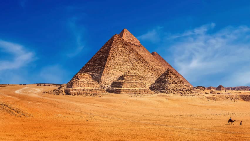 The Great Pyramids of Giza A Majestic View with Camels Traversing the Desert Landscape