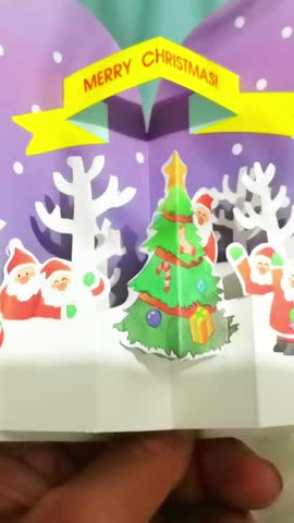 Experience the magic of a Christmas pop-up card. Watch Santa, a cheerful snowy landscape, and a festive Christmas tree come to life, spreading joy and holiday spirit.