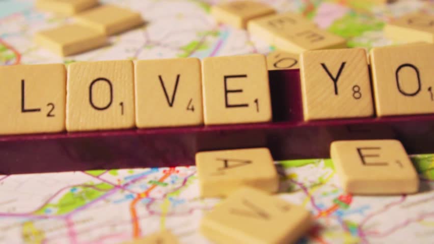 Scrabble letter tiles arranged to spell “I love you” on a flat surface. Romantic creative concept for love, relationships, affection, and Valentine’s Day design.