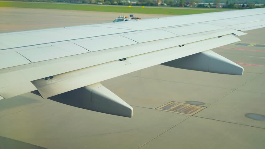 Jet extending flaps during pre takeoff check at airport. Passenger airplane deploying wing surfaces before departure. Aircraft preparing for takeoff with flaps moving on tarmac
