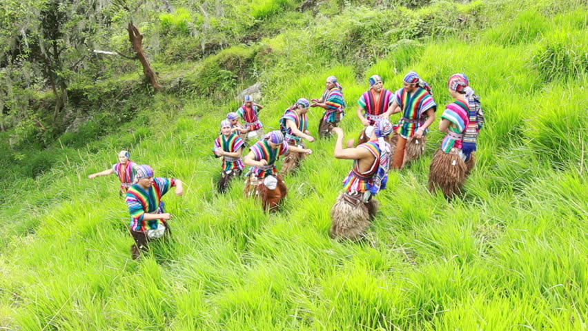 Twelve dancers performing a Ecuadorian dance, wearing traditional costumes,