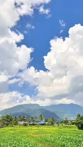Clouds move over the mountains on a blue-sky day.