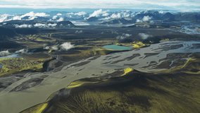 Aerial view of a vast braided river system carving through the stark volcanic landscape, interspersed with vivid green moss and lakes, Landmannaleið, Rangárþing ytra, Iceland. - Powered by Shutterstock - Get 15% off with code: PIKWIZARD15
