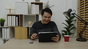 happy young man using digital tablet and wireless earbuds making video call in home office - Powered by Shutterstock - Get 15% off with code: PIKWIZARD15