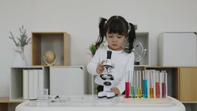 toddler girl scientist looking through a microscope. learning science - Powered by Shutterstock - Get 15% off with code: PIKWIZARD15