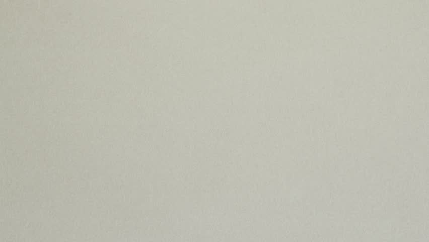 Red crumpled paper unfolds on grey in a stop motion transition