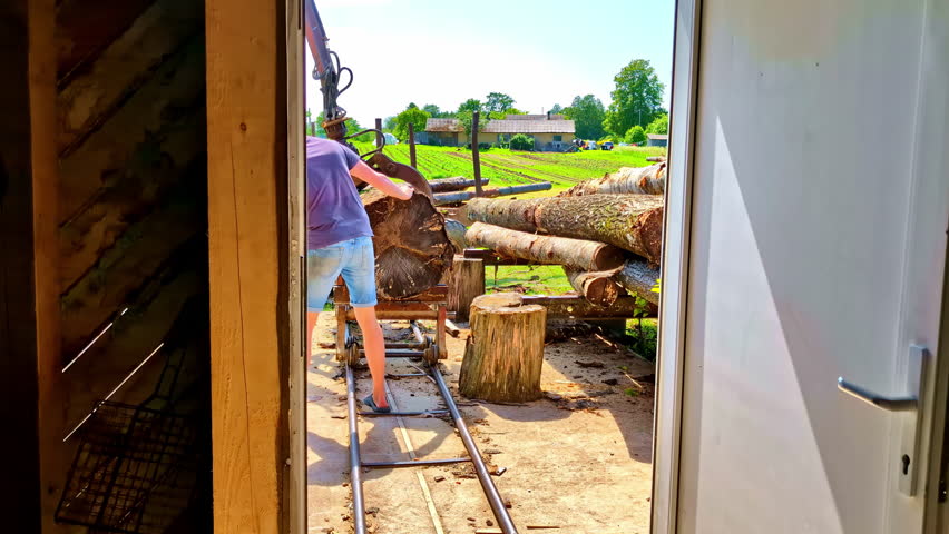 Man Giving Commands to Crane operator putting Log on Carts at Sawmill