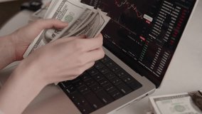 Hands counting cash money in front of laptop screen with crypto trading platform, symbolizing profit, finance growth, and success in digital investment economy - Powered by Shutterstock - Get 15% off with code: PIKWIZARD15