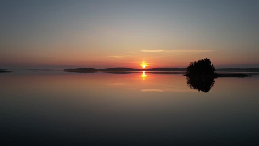 Breathtaking drone footage of a magical sunset over Lake Saimaa, Finland, capturing stunning colors, calm reflections, and peaceful Nordic nature.
