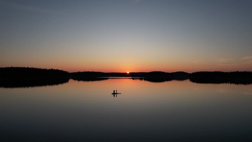 Aerial shot from lake Saimaa. The biggest lake from Finnland. With some people on a boat durin a stunning sunset.