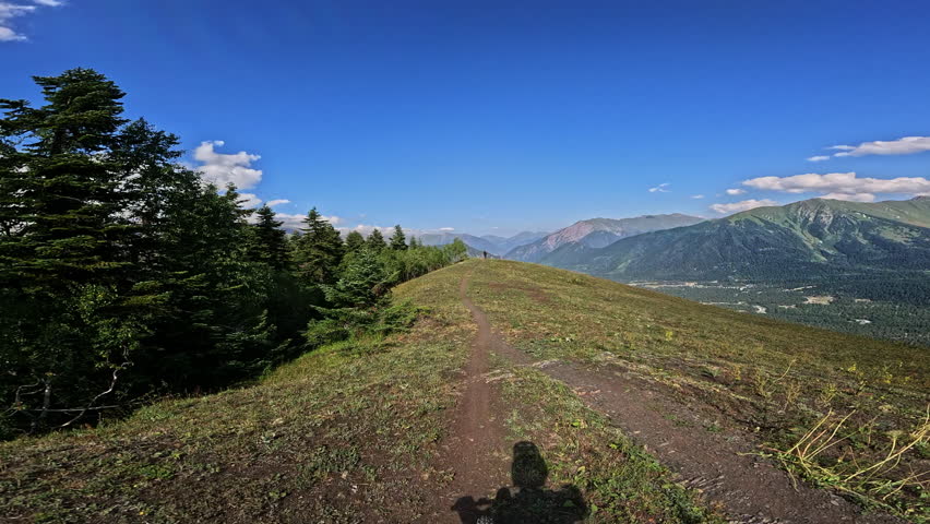 Scenic mountain trail progression with vibrant landscape and clear blue sky
