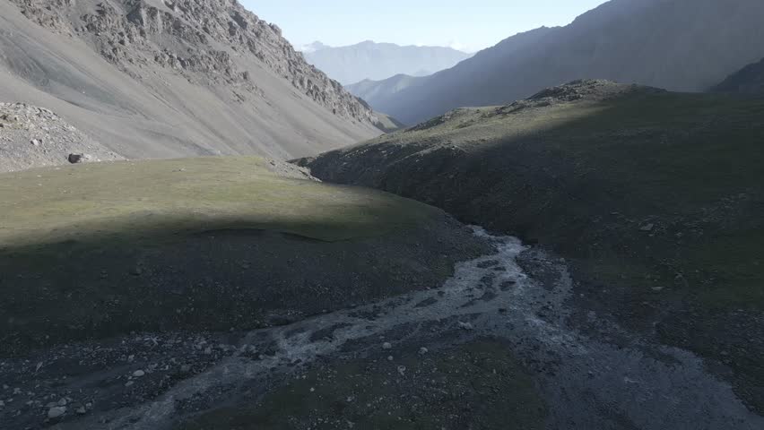 River carving a deep scar through the valley floor.