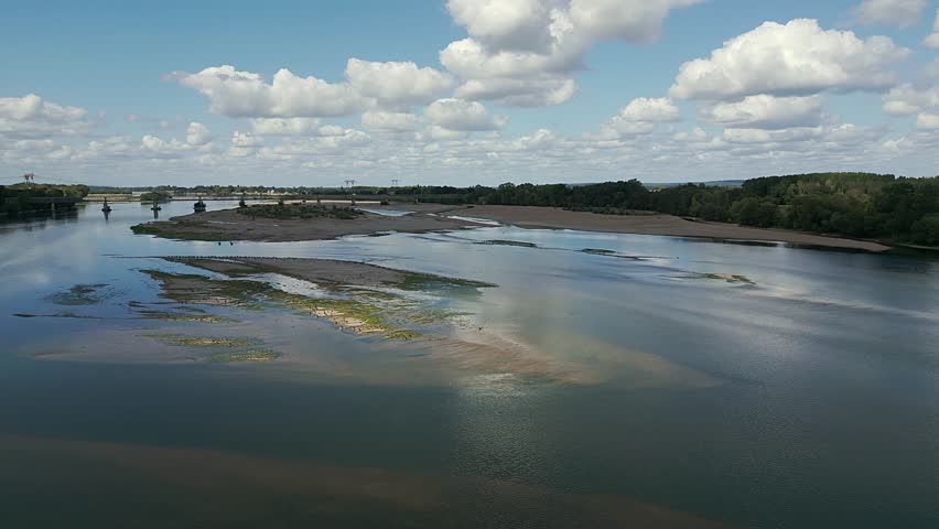 Drone 4K footage of the Loire River at Montsoreau, France, showing flocks of water birds resting on scenic river sandbanks.