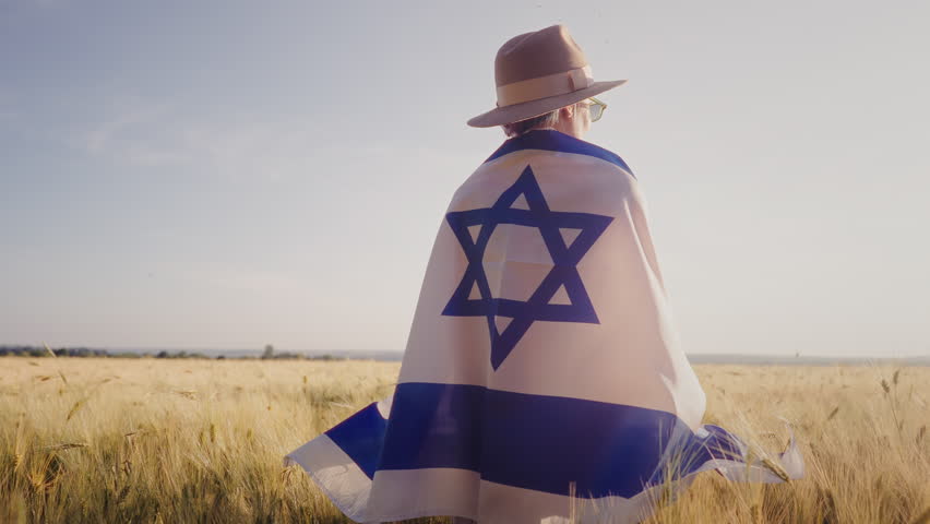 Jewish Woman Stands Alone In Open Field, Holding Israeli National Flag. Heritage