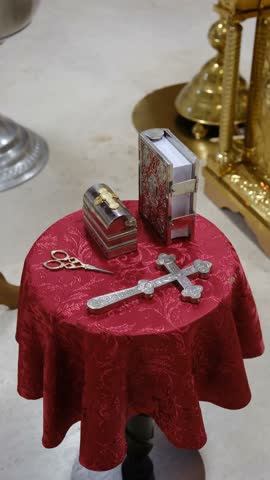Sacred objects on a red altar cloth with ornate religious items and golden altar.