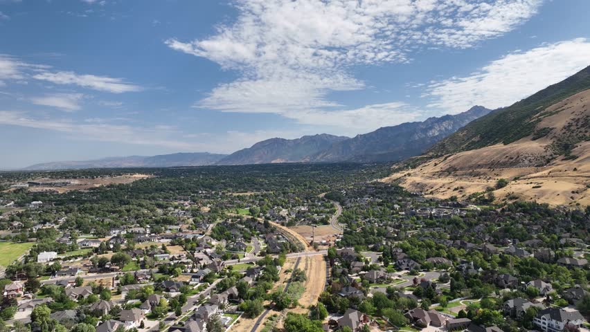 From Draper, Utah looking towards the South Salt Lake Valley along the Wasatch Front mountain range - pullback aerial flyover