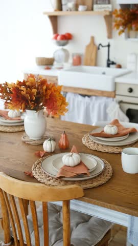 Autumn table setting with colorful maple leaves and mini pumpkins on plates