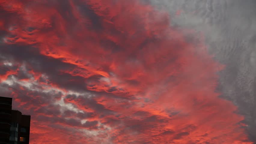 Timelapse of amazing colorful red grey textured clouds over city buildings. Amazing sunset sky. Natural real colors, contrast, shadows	
