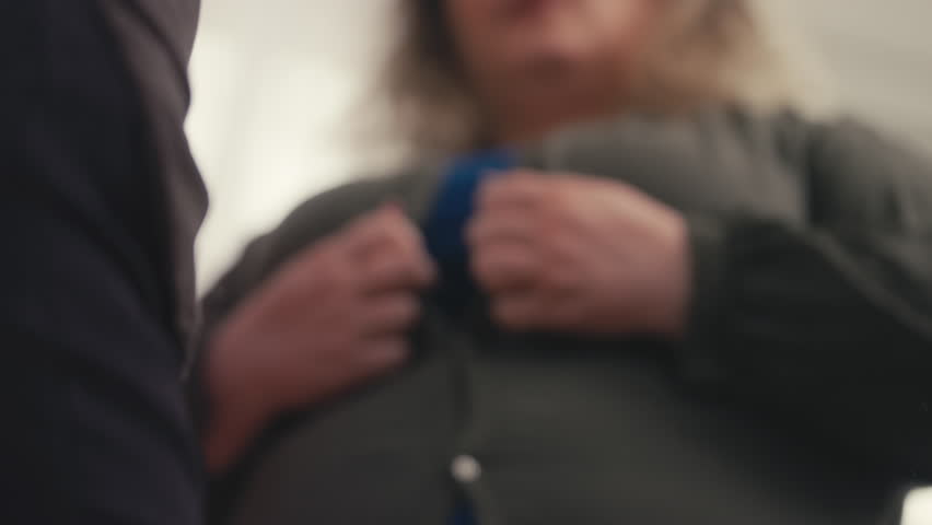 Large woman buttoning blouse near mirror, feeling upset about her extra weight