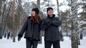 Happy couple in love walking hand in hand through a beautiful snowy park. Romantic man and woman enjoying a winter stroll together - Powered by Shutterstock - Get 15% off with code: PIKWIZARD15