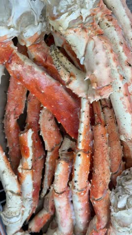 Crab legs piled in a heap showcasing strong texture and vibrant color for seafood background video