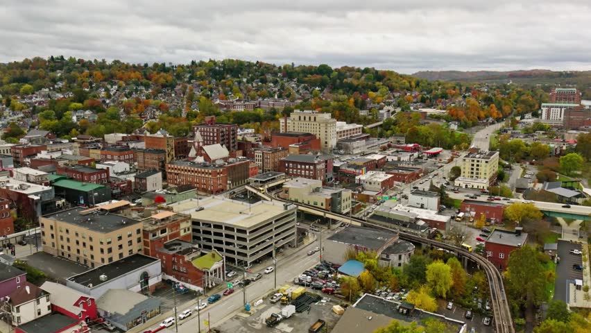 Aerial view of a city with colorful autumn trees and cloudy skies